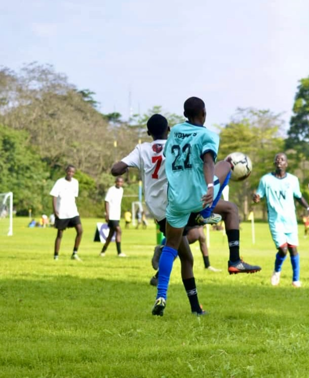 Youth football match in action — players competing for the ball on the pitch